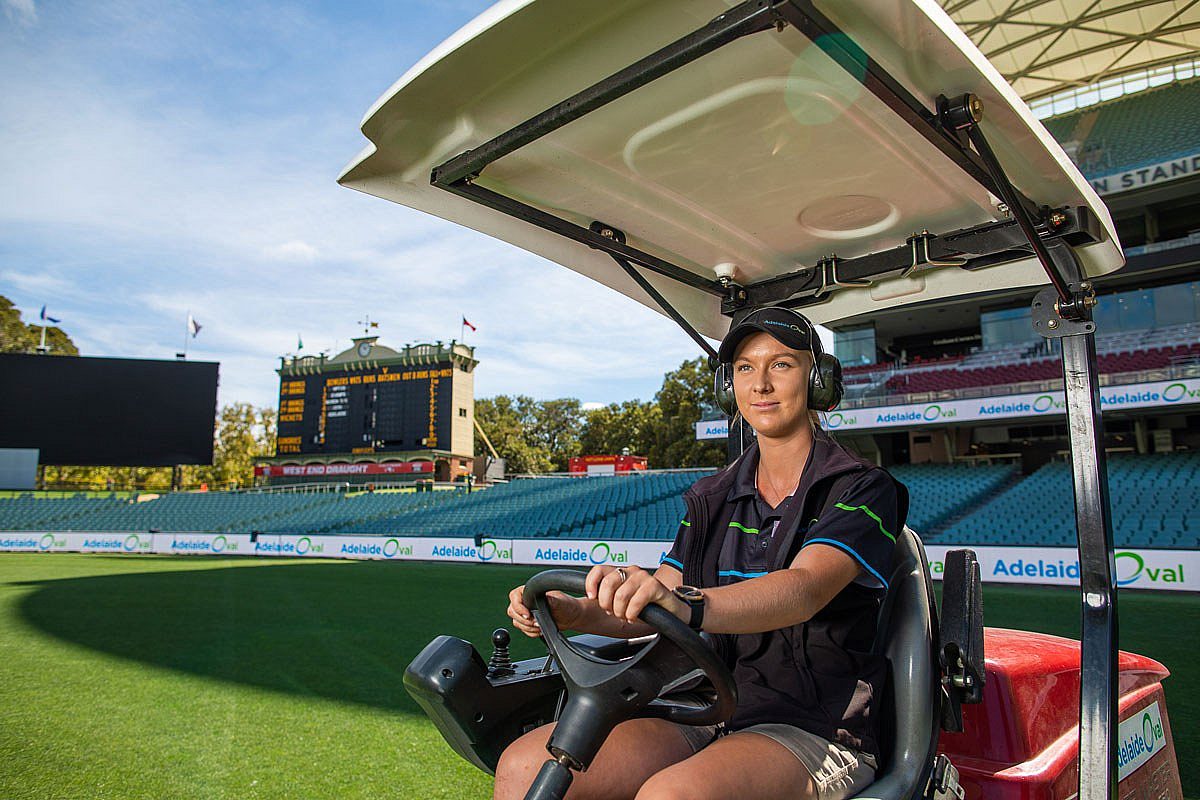 Female landscaping apprentice driving a ride on lawn mower at Adelaide Oval