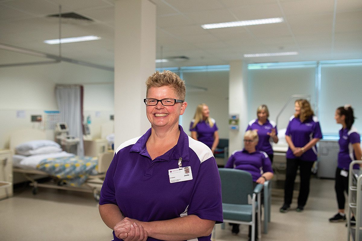 Health care worker standing in front of a team of nurses