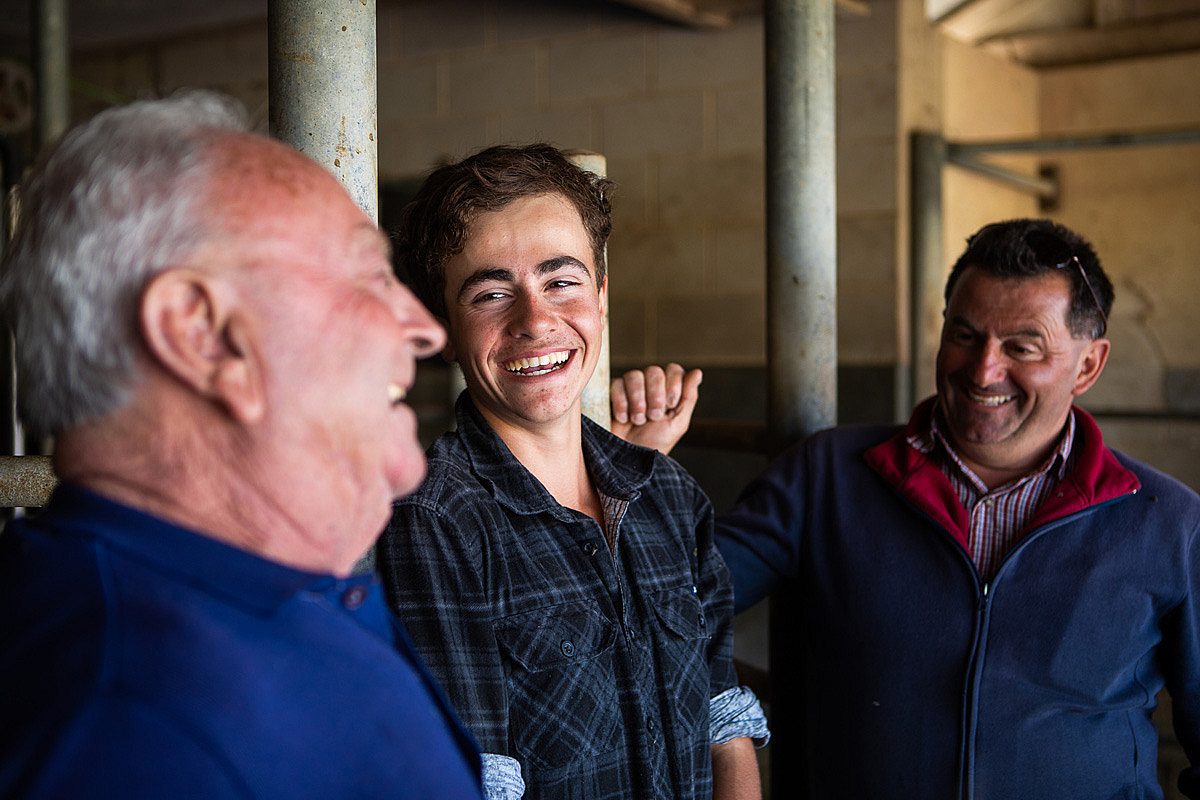 Young male apprentice laughing with two colleagues in an industrial setting