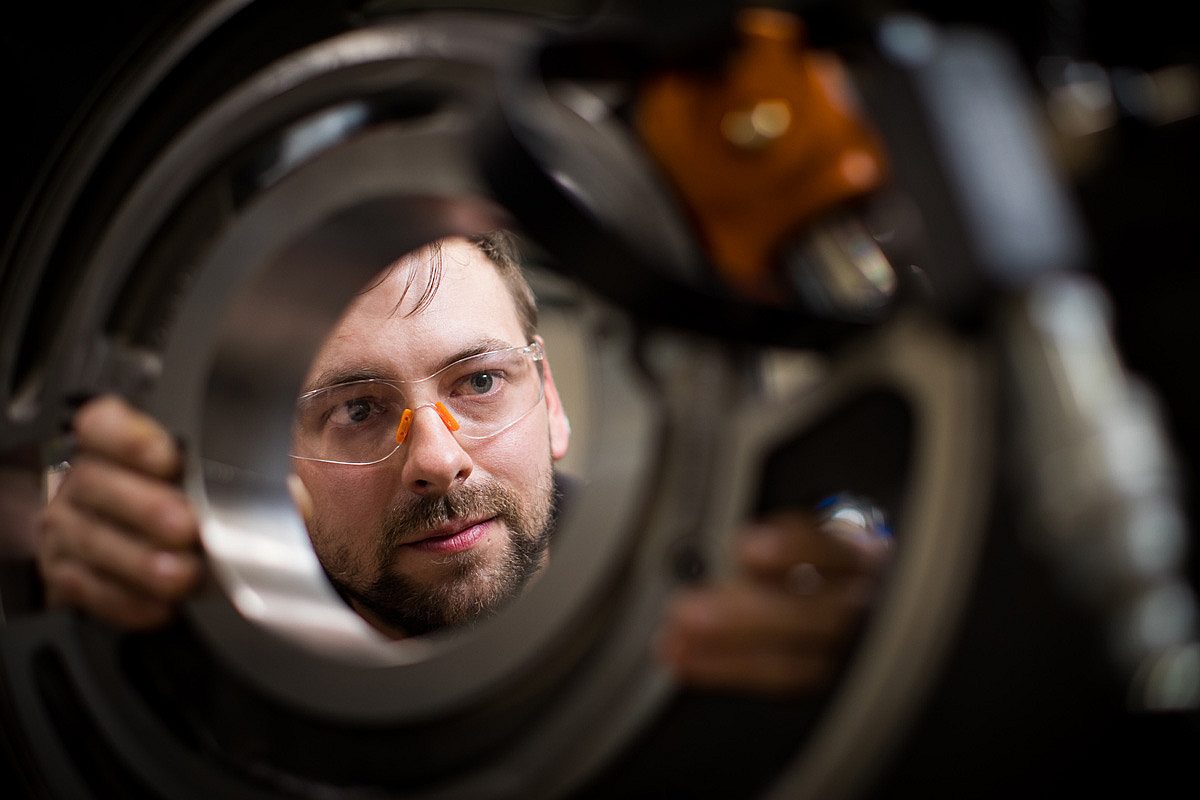 Mechanical engineering apprentice working on large piece of machinery