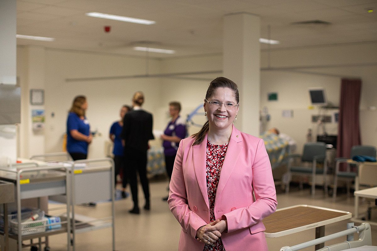 Mature age health care professional with team of nurses in health care setting