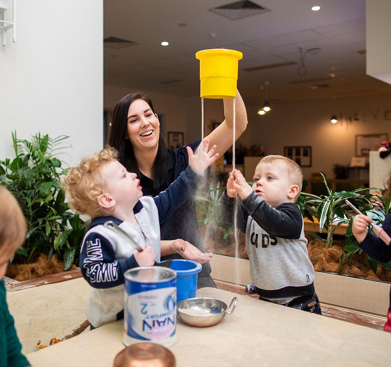 Child care worker playing with two kindergarten aged children