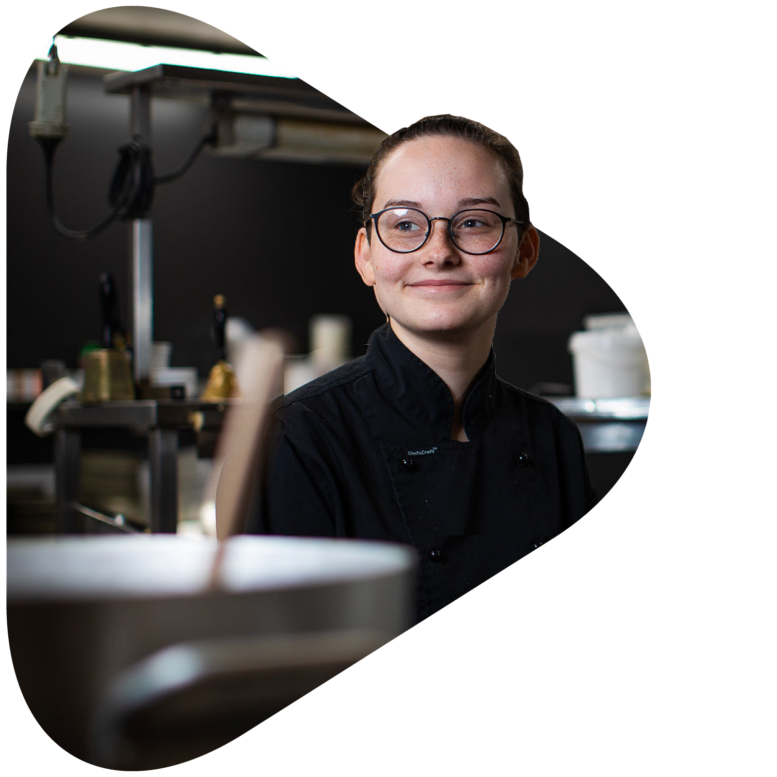 A hospitality apprentice chef in a commercial kitchen