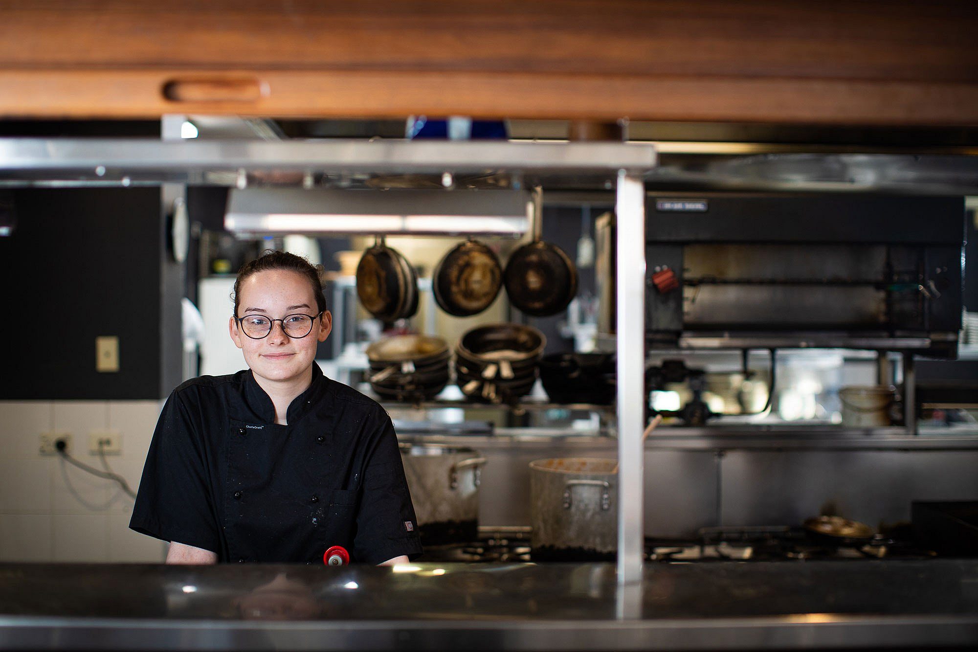 Female chef apprentice standing behind bench in hospitality setting
